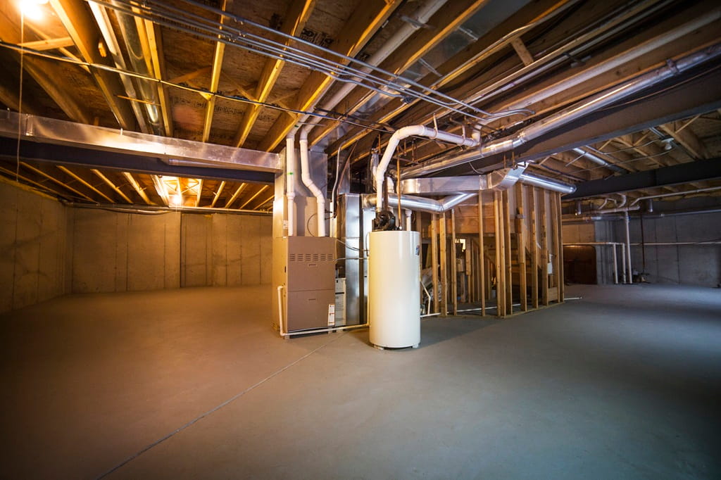 HVAC system and water heater in an unfinished residential basement.